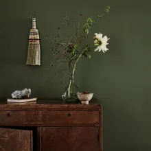 syvänvihreä seinä ja ruskea lipasto