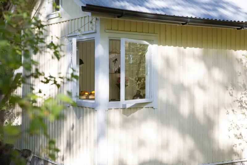 Vaalean keltainen mökki