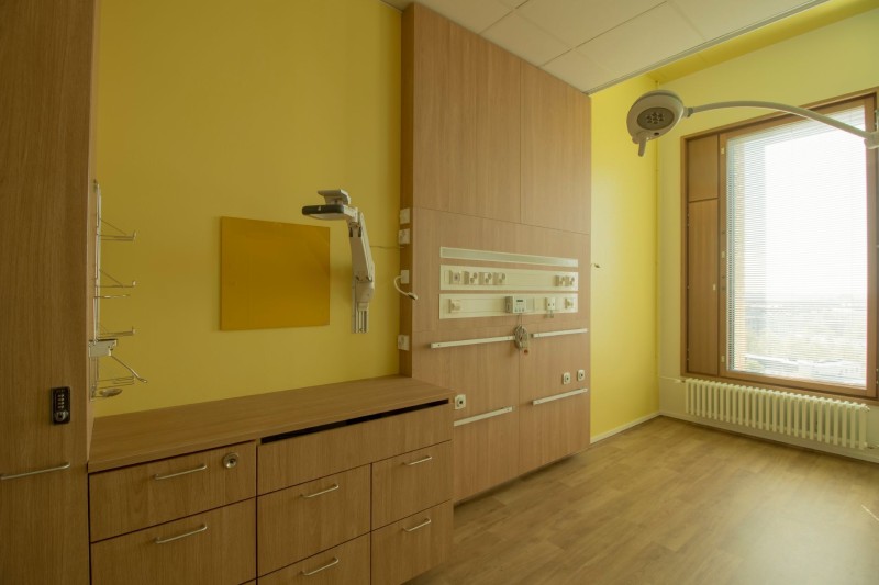 Lastensairaalan potilashuoneen keltaiseksi maalattu seinä. 