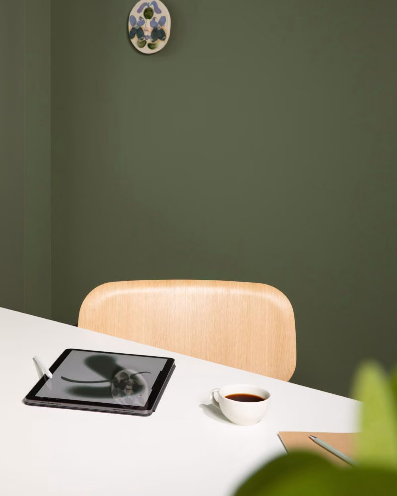 Tummanvihreäksi maalattu toimiston työtila