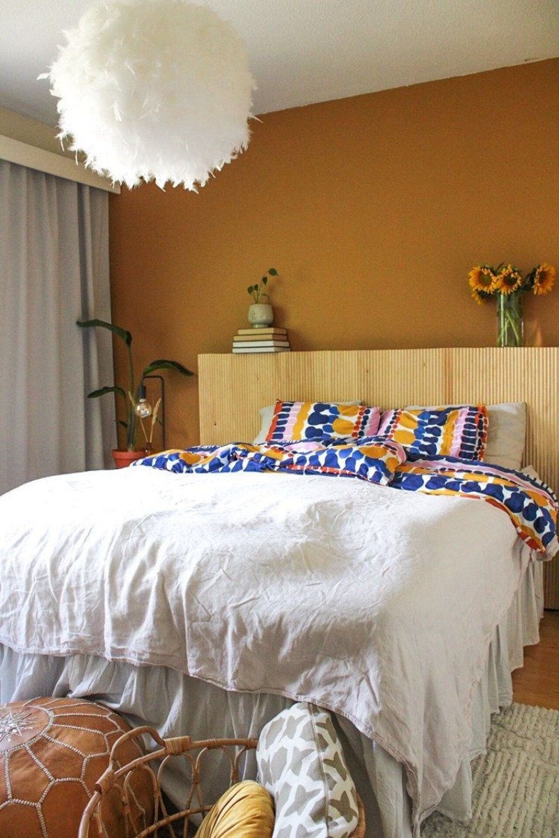 Makuuhuoneen seinä lämpimällä keltaisella sävyllä ja yhteensopivilla lakanoilla