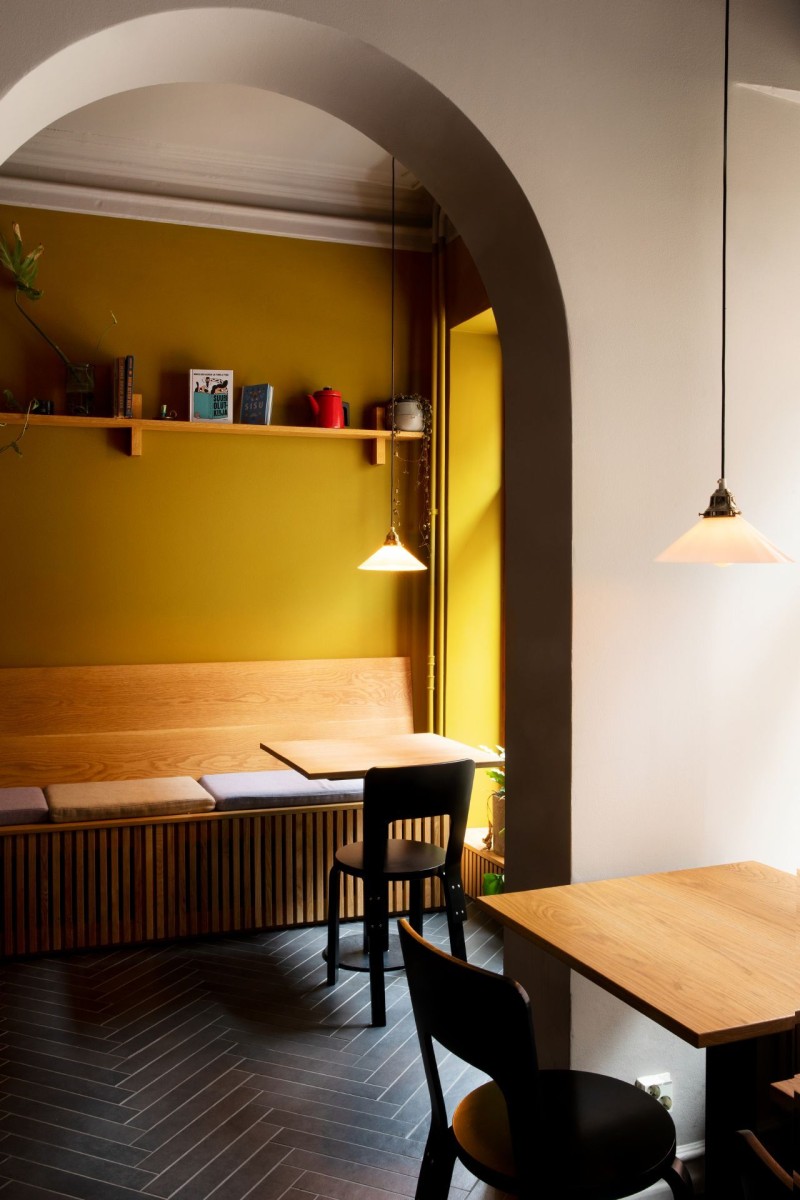 Lämmin keltainen seinä kotoisassa ravintolatilassa 