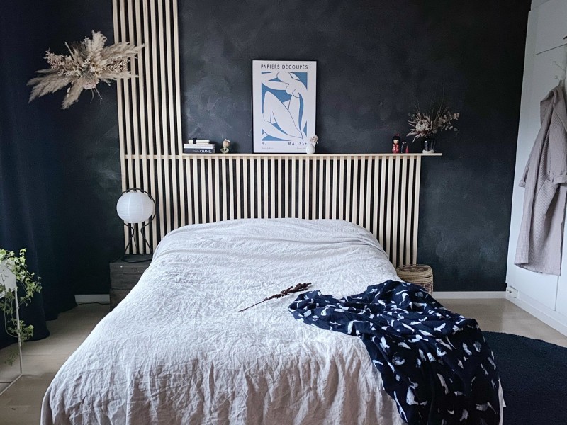Makuuhuone, jossa siniset seinät ja luonnonmateriaaleja